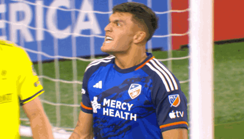 A Soccer Player Wearing A Blue Mercy Health Shirt GIF