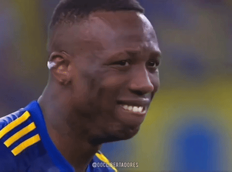 a soccer player wearing a blue shirt with yellow stripes on the sleeves