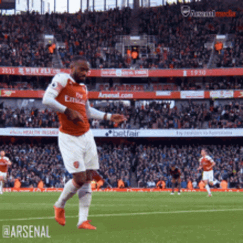 A Soccer Player Wearing A Fly Emirates Jersey Is Kicking A Ball GIF