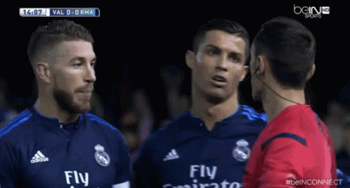 a soccer player wearing a fly emirates jersey is talking to another player
