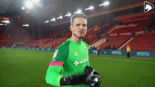a soccer player wearing a green jersey that says umbro