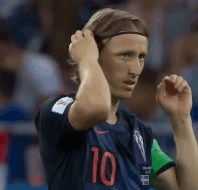 A Soccer Player Wearing A Headband Is Adjusting His Hair While Standing On The Field . GIF