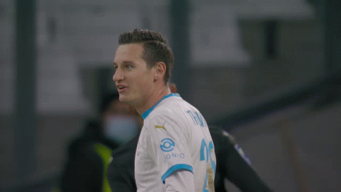 A Soccer Player Wearing A Medina 14 Jersey Stands Next To Another Player GIF