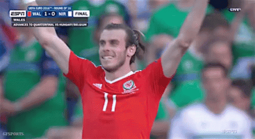 A Soccer Player Wearing A Number 11 Jersey Is Raising His Arms In The Air GIF