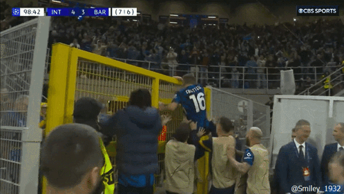 a soccer player wearing a number 16 jersey is jumping over a fence