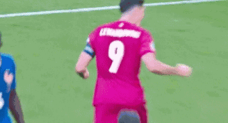 A Soccer Player Wearing A Pink Jersey With The Number 9 On It Is Kicking A Ball . GIF