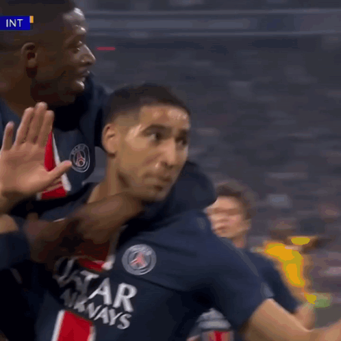 a soccer player wearing a qatar airways jersey is giving a high five
