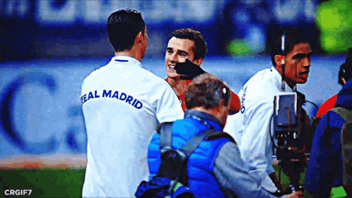 A Soccer Player Wearing A Real Madrid Shirt Talks To Another Player GIF