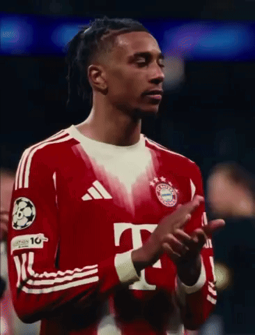 a soccer player wearing a red adidas jersey is clapping