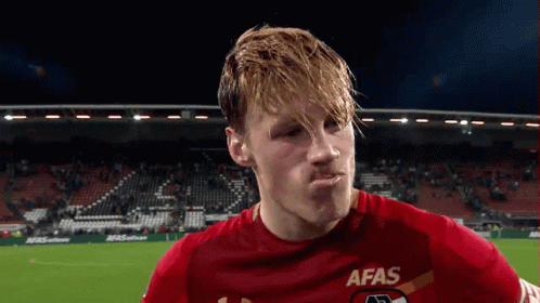 a soccer player wearing a red afas jersey