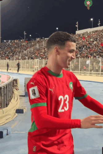 A Soccer Player Wearing A Red And Green Jersey With The Number 23 On It GIF