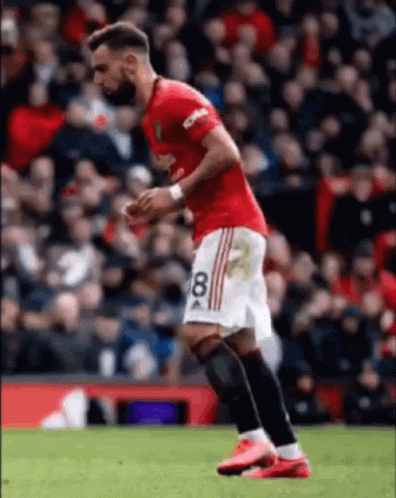 A Soccer Player Wearing A Red And White Jersey With The Number 8 On It Is Running On The Field . GIF