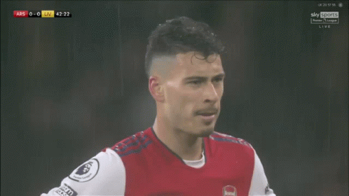 a soccer player wearing a red and white jersey with the word arsenal on the front