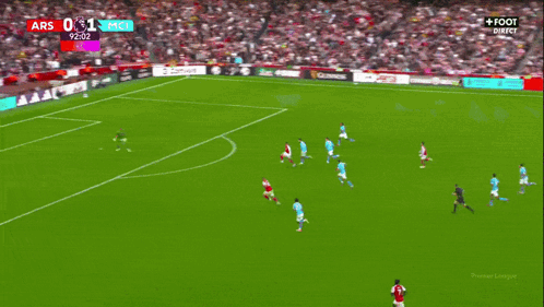 a soccer player wearing a red emirates jersey is being helped by another player