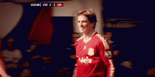 A Soccer Player Wearing A Red Jersey Is Standing In A Locker Room . GIF