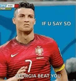 A Soccer Player Wearing A Red Jersey Is Standing On A Field And Saying `` If U Say So Georgia Beat You '' . GIF