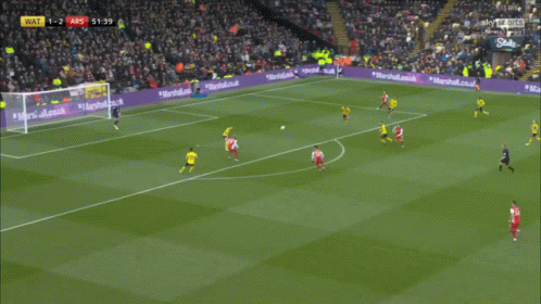 a soccer player wearing a red jersey that says emirates fly emirates on it