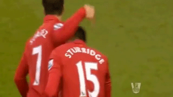 A Soccer Player Wearing A Red Jersey That Says Standard Chartered Is Giving Another Player A High Five GIF