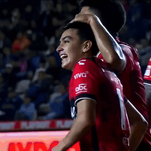 a soccer player wearing a red jersey that says viva on it