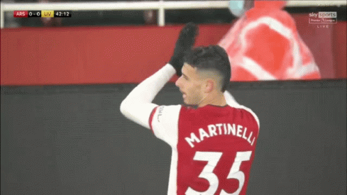 a soccer player wearing a red jersey with martinelli 35 on it
