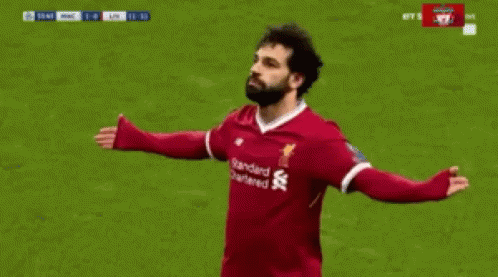 A Soccer Player Wearing A Red Jersey With The Word Standard Chartered On It Is Celebrating A Goal . GIF