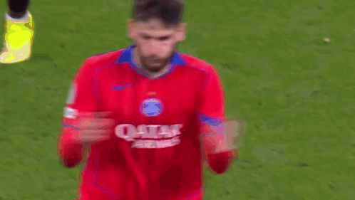 A Soccer Player Wearing A Red Qatar Airways Jersey Is Standing On A Soccer Field . GIF