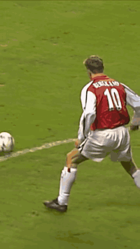 a soccer player wearing a red shirt that says ' dri ' on it is being tackled by another player