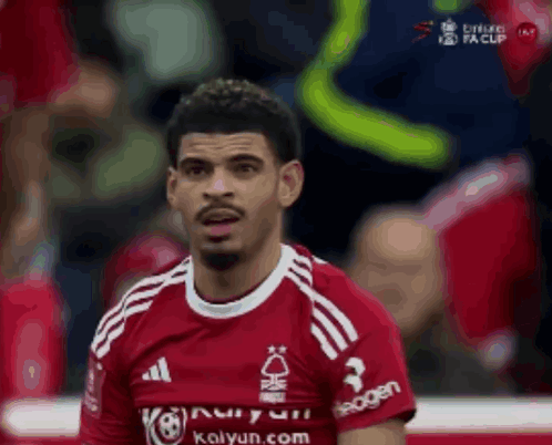 a soccer player wearing a red shirt that says kalyun.com on it