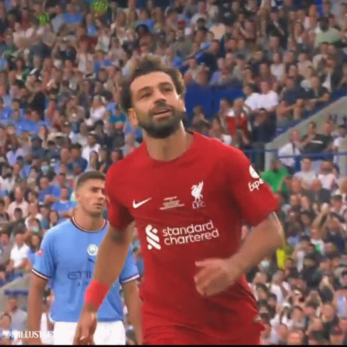 A Soccer Player Wearing A Red Shirt That Says Standard Chartered Is Running On The Field . GIF