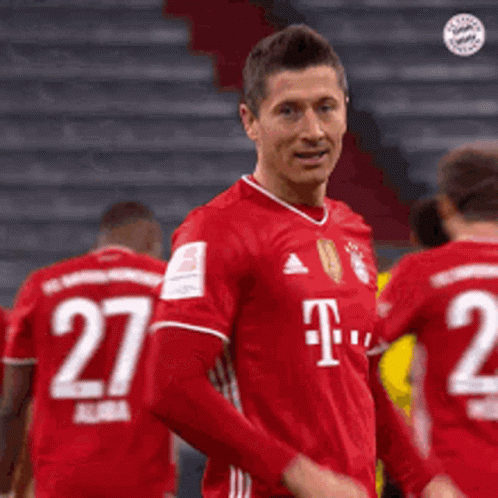 A Soccer Player Wearing A Red T-Mobile Jersey Is Standing In Front Of His Teammates . GIF
