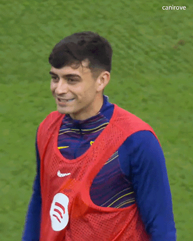 a soccer player wearing a red vest with spotify on it