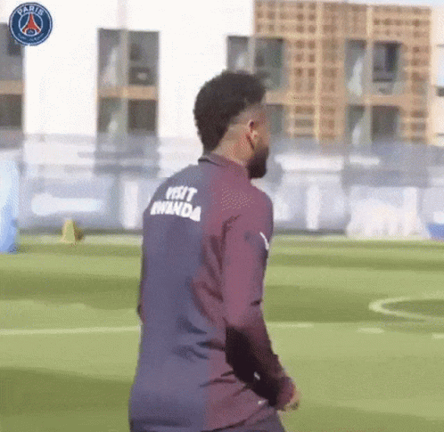 A Soccer Player Wearing A Shirt That Says Visit Rwanda On The Back Is Walking On A Field . GIF