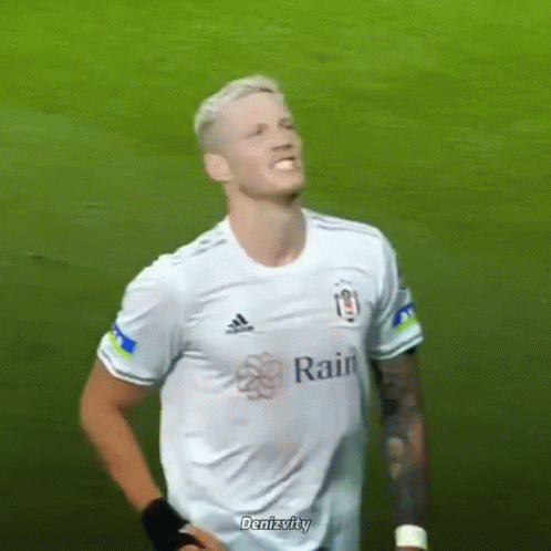 a soccer player wearing a white adidas shirt is standing on a field .