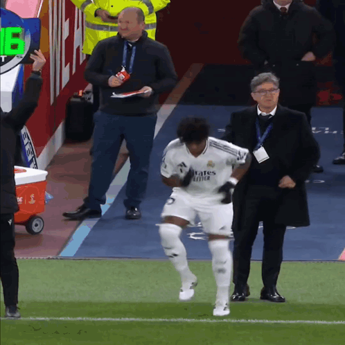 a soccer player wearing a white jersey that says ' emirates fly better '