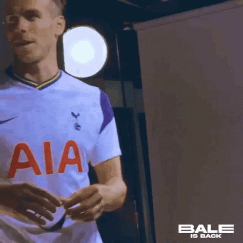 A Soccer Player Wearing A White Jersey With Aia On The Front Is Standing In Front Of A Light . GIF