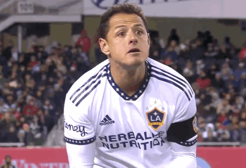 a soccer player wearing a white jersey with the word herbalife on it