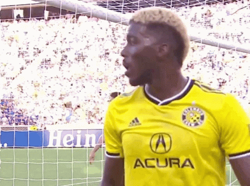 A Soccer Player Wearing A Yellow Acura Jersey GIF