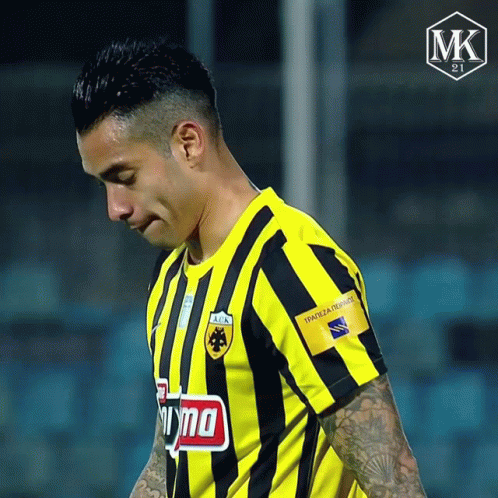 A Soccer Player Wearing A Yellow And Black Striped Shirt Has A Tattoo On His Arm That Says Mk On It GIF