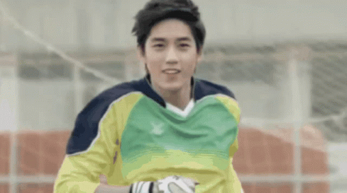 a soccer player wearing a yellow and green jersey with a x on it