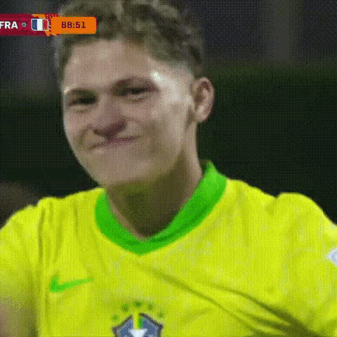 A Soccer Player Wearing A Yellow And Green Shirt Is Smiling . GIF