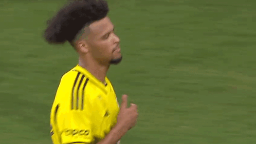A Soccer Player Wearing A Yellow Jersey Is Standing On A Field . GIF