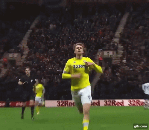 a soccer player wearing a yellow jersey that says 32red on it