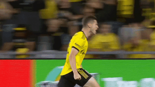 A Soccer Player Wearing A Yellow Shirt And Black Shorts GIF