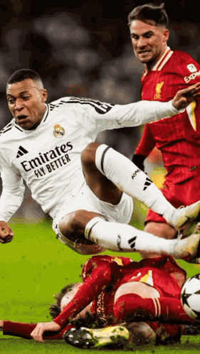 A Soccer Player Wearing An Emirates Fly Better Shirt Is Being Tackled By Another Player GIF
