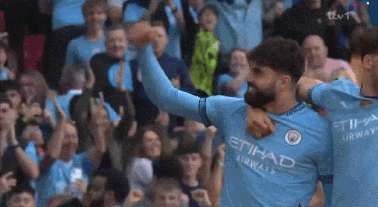 a soccer player wearing an etihad airways jersey is celebrating a goal