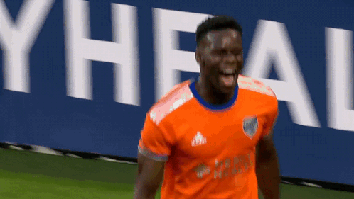 A Soccer Player Wearing An Orange Adidas Jersey Is Celebrating GIF