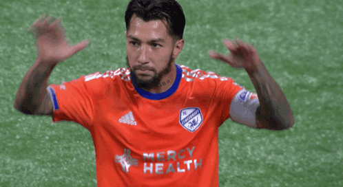 A Soccer Player Wearing An Orange Jersey That Says Mercy Health On It GIF