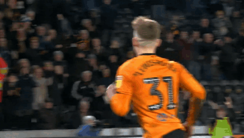 A Soccer Player Wearing An Orange Jersey With The Number 31 On The Back GIF