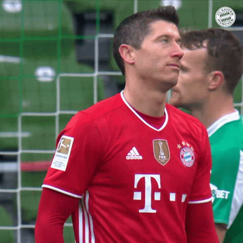a soccer player wears a red adidas shirt with the letter t on it