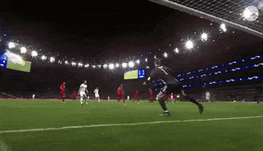 a soccer player with the number 11 on his jersey kicks the ball into the net